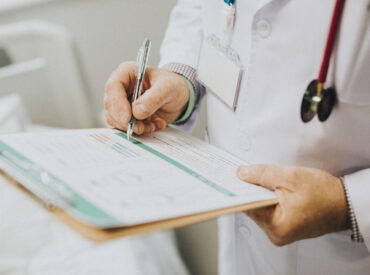 Physician noting down symptoms of a patient